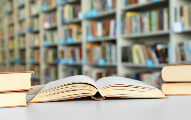 Many books on a table in a library