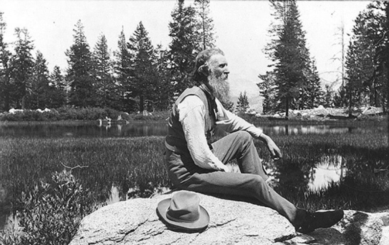 [John Muir, full length portrait,…seated on rock with lake and trees in background]. c1902. Prints & Photographs Division from Library of Congress